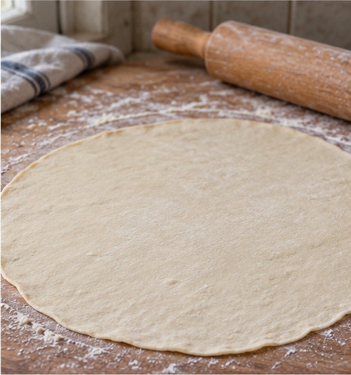Roll a dough ball into a very thin round.